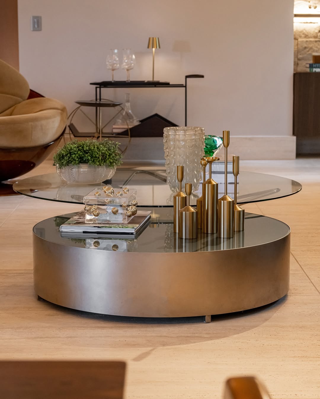 Modern living room with a round metallic coffee table and decorative items.