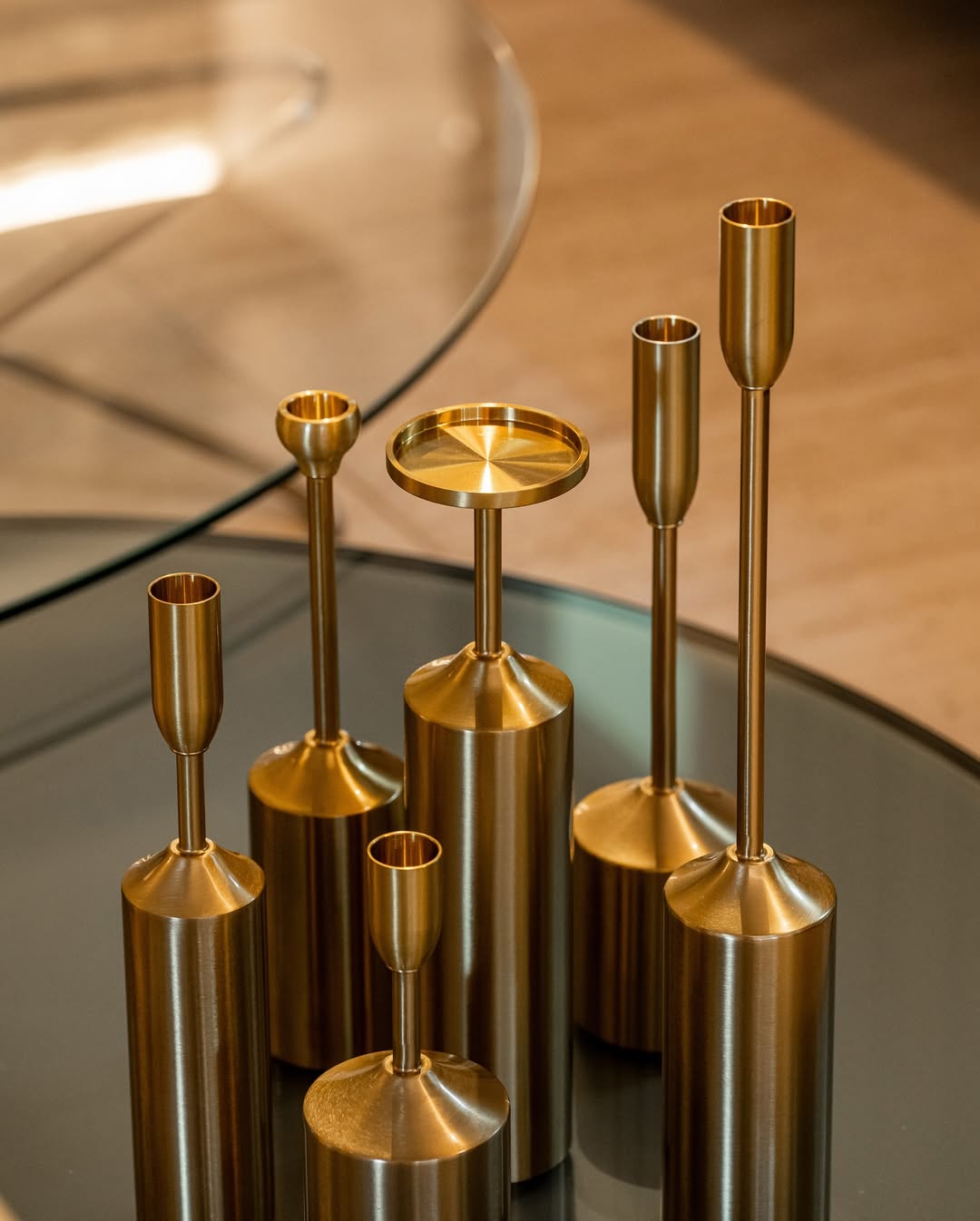 Set of gold candle holders on a reflective surface